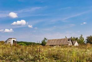 linda e velha casa de fazenda abandonada na zona rural em fundo natural foto