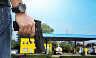 Pistola automática de 9 mm segurando na mão direita do atirador, conceito de segurança, roubo, gangster, guarda-costas em todo o mundo. foco seletivo na pistola. foto