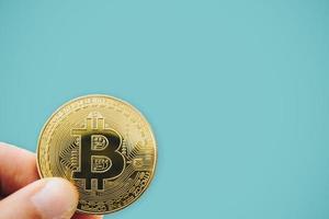 mão segurando um símbolo de bitcoins como criptomoeda de dinheiro digital foto