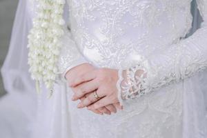 fechar acima do uma noivas mãos com casamento anel em dedo foto