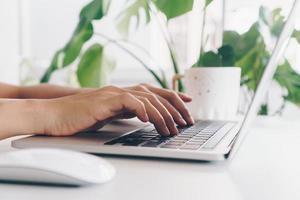 pessoa usando um laptop para estudar na mesa de trabalho foto