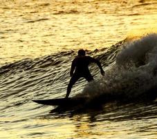 surfista ao pôr do sol foto