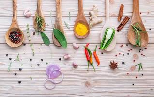 ervas frescas e especiarias em colheres foto