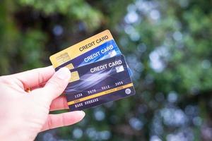 uma mão segurando cartões de crédito com um fundo bokeh, conceito de liberdade financeira foto