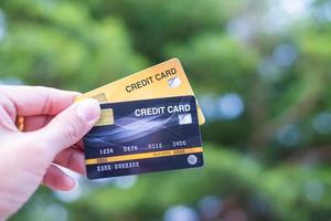uma mão segurando cartões de crédito com bokeh de fundo, conceito de liberdade financeira