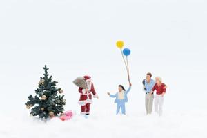 pessoas em miniatura com o papai noel com presentes para crianças, conceito de natal foto