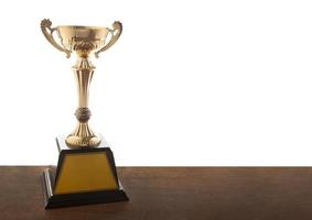 troféu de ouro em uma mesa isolada em um fundo branco foto