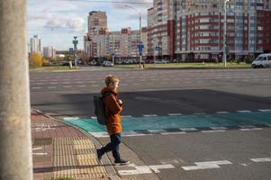 uma aluna cruzes a estrada às uma pedestre cruzando foto