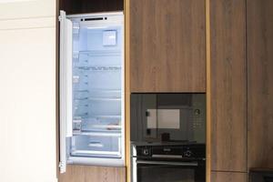 cozinha mobília com a aberto geladeira microondas e forno foto