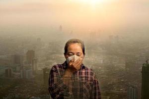 mulher usando máscara de proteção respiratória n95 pm 2.5 contra poluição do ar e partículas de poeira excedem os limites de segurança. saúde, meio ambiente, conceito de ecologia. alergia, dor de cabeça. perigo aéreo na cidade. foto