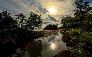 de praia tarde panorama com pedras e árvores foto