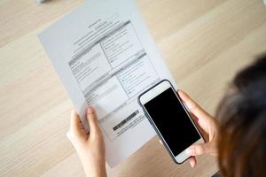 mulher usando uma Smartphone para Varredura uma Barra código para pagar vários despesas crédito cartão depois de recebendo a fatura enviei para casa conectados conta Forma de pagamento conceitos. foto