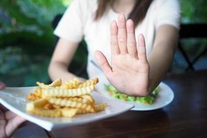 mulheres recusar para comer frito ou francês fritas para peso perda e Boa saúde. foto