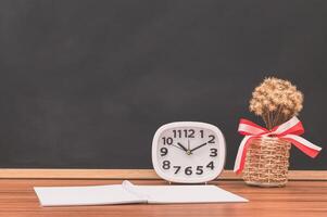 o caderno e o relógio na mesa foto