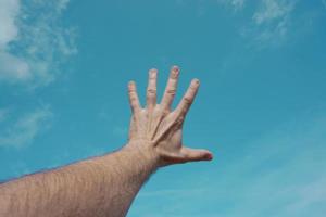 mão para cima gesticulando no céu azul, sentimentos e emoções foto