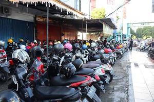 kudus, dezembro 2022. foto do uma lotado moto estacionamento muitos dentro a kudus cidade quadrado. lotado visitantes venha para a kudus exibição