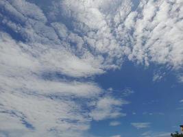 lindas nuvens brancas sobre fundo de céu azul profundo. grandes nuvens fofas e brilhantes cobrem todo o céu azul. foto