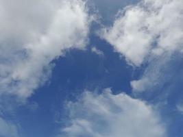 lindas nuvens brancas sobre fundo de céu azul profundo. grandes nuvens fofas e brilhantes cobrem todo o céu azul. foto