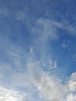 lindas nuvens brancas sobre fundo de céu azul profundo. grandes nuvens fofas e brilhantes cobrem todo o céu azul. foto