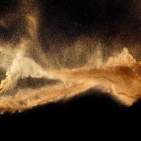 areia explosão isolado em Preto fundo. congelar movimento do arenoso poeira splash.sand textura conceito. foto