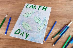 crianças desenhando do a planeta terra com uma mundo mapa com multicolorido lápis e ponta de feltro canetas em branco papel. a conceito do a dia do Paz e terra, de Meio Ambiente proteção. foto