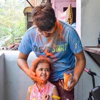 indiano família pessoas jogando cores em holi festival, segurando diferente cores, holi festival celebrações dentro Délhi, Índia foto