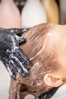 jovem mulher recebendo cabelo lavar foto