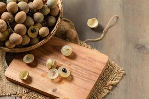 fresco longan frutas em madeira prato e velho madeira fundo, foto