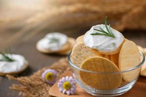 delicioso biscoitos com creme queijo e alecrim em topo dentro copo. foto