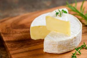 fatiado queijo Camembert queijo com Tomilho em madeira placa. queijo Camembert é uma úmido, macio, cremoso, foto