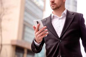 retrato do uma jovem homem de negocios dentro uma terno telefone fechar acima foto