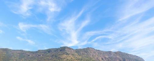 montanha com lindo nuvens e azul céu fundo foto