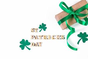 trevo e presente com fita verde sobre um fundo branco. símbolos de boa sorte para st. dia de patrick. feriado irlandês. foto
