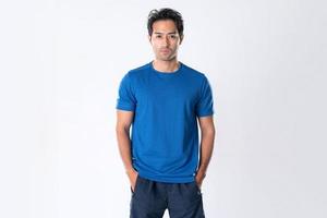 elegante jovem homem dentro azul camisa em pé em branco fundo