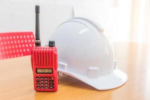 rádio walkie-talkie vermelho e capacete de segurança branco foto