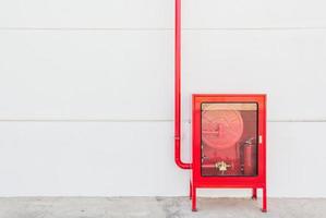 armário de mangueira de incêndio vermelho e extintor foto