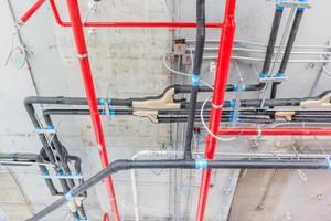 tubos de ventilação em material de isolamento e sprinkler contra incêndio em tubo vermelho foto