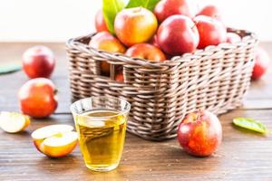 suco de maçã no copo e maçãs na cesta foto