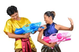 jovem casal desfruta com pistola de água no festival songkran foto
