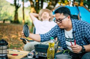 ásia relaxado homem sentado e esperando para dele amigo cozinhando foto