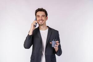 retrato do empresário bonito feliz falando pelo telefone móvel e segurando café quente isolado sobre fundo branco foto