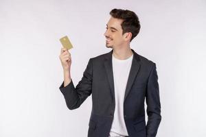 retrato do jovem empresário bonito sorridente, mostrando o cartão de crédito isolado sobre fundo branco foto