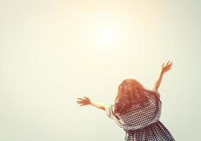 jovem mulher levantar dela mãos para dentro a céu com nascer do sol tão fresco. foto