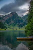 uma montanha lago com barcos em uma lindo montanha, em nublado clima foto