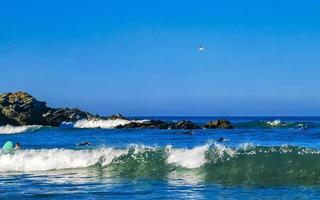 belas rochas falésias surfista ondas na praia puerto escondido méxico. foto