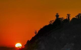 colorida dourado pôr do sol grande onda pedras de praia porto escondido México. foto