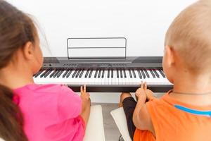 irmão e irmã jogando piano foto