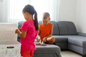 as crianças brincam com um designer de brinquedos no chão do quarto das crianças. duas crianças brincando com blocos coloridos. jogos educativos de jardim de infância. foto