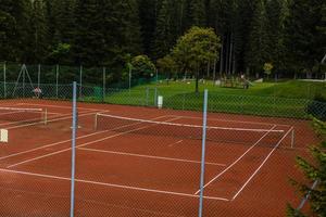 tênis quadra e cercado de árvores e colinas. a perfeito Lugar, colocar para relaxamento e exercício para uma Boa saúde foto