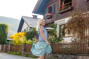 jovem mulher é em pé de de madeira casas. Vila dentro montanhas. viagem, estilo de vida conceito. Alpes, Europa. foto